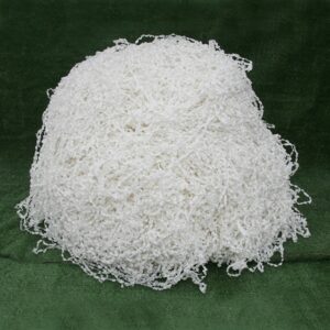 A white ball of shredded paper on top of green cloth.